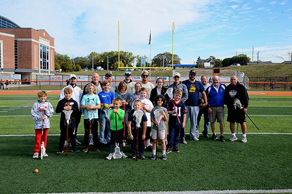 A group photo of River City Sticks Lacrosse coaching staff and participants after
          a clinic event at the football field at Lawrenceburg High School.